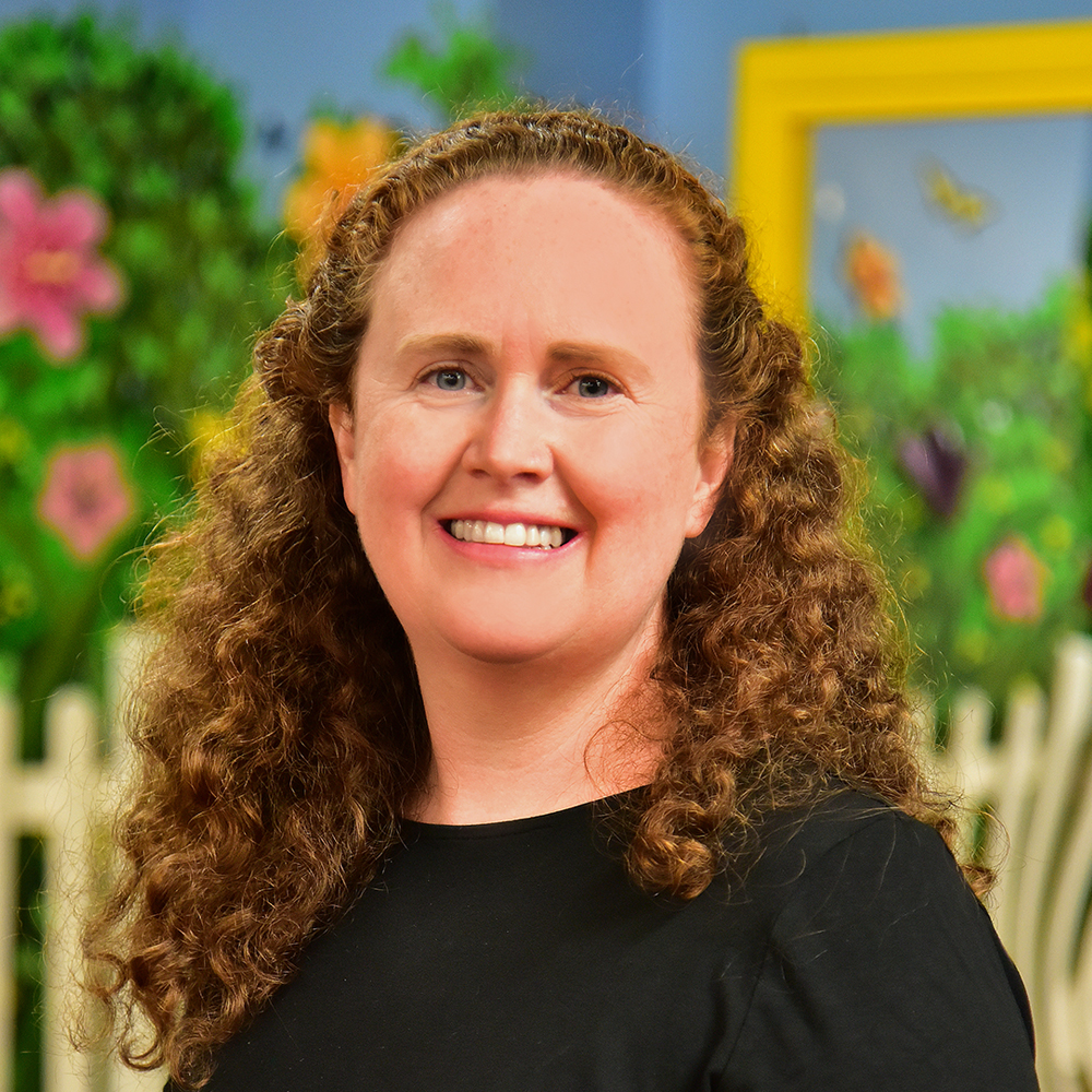 Eileen Marriott Woman with curly light brown hair wearing black shirt and smiling