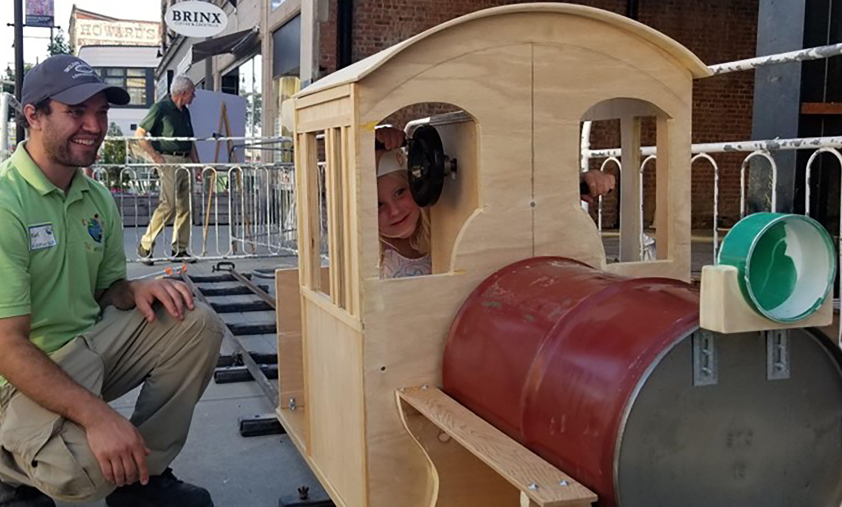 KidsPlay Birthday - Kid riding a wooden train back and fourth.